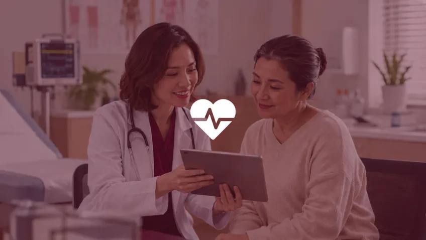 A doctor showing a tablet to a patient, with a heartbeat icon