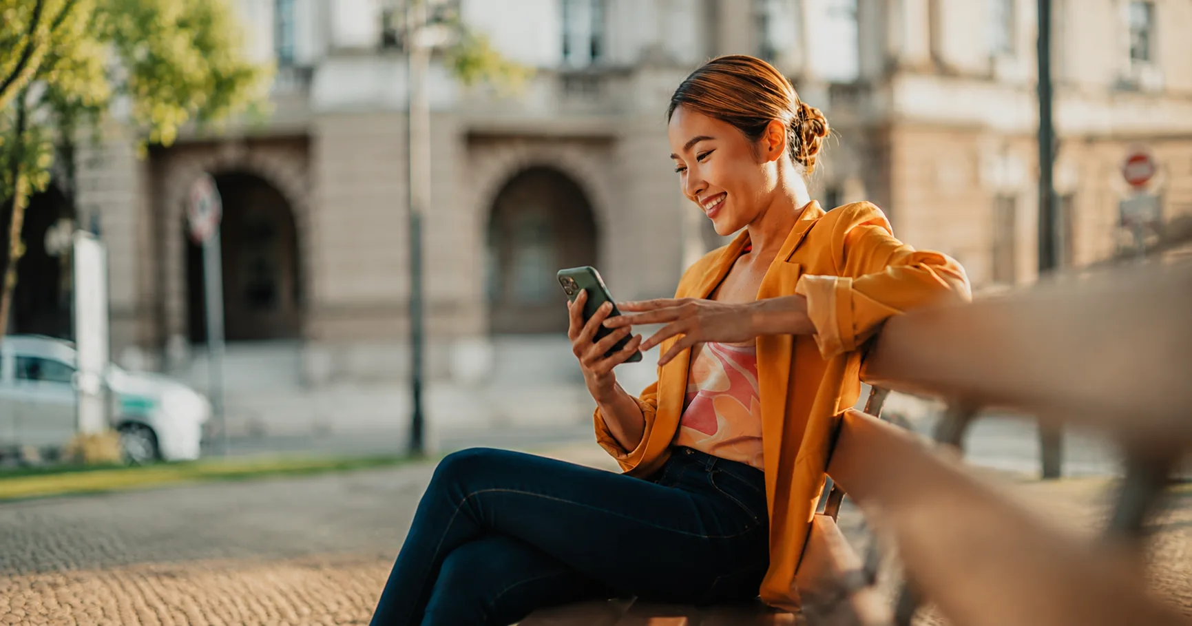 A woman smiling at her phone in a cafe